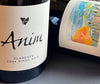 Wine bottle with 'Anim' label on a gray surface
